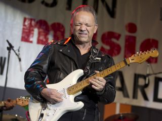 Jimmie Vaughan Holding A Guitar