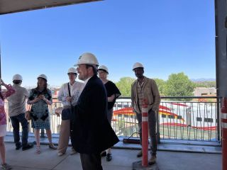 A Group Of People Wearing Hardhats And Standing On A Bridge