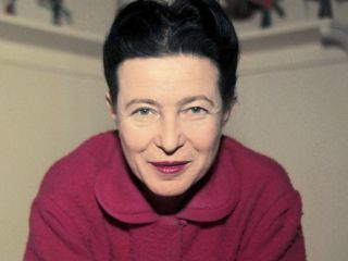 Simone De Beauvoir In A Red Shirt Is Looking At The Camera