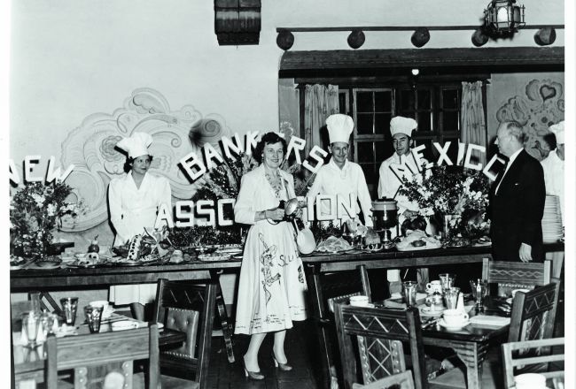 A Group Of People Standing In Front Of A Buffet
