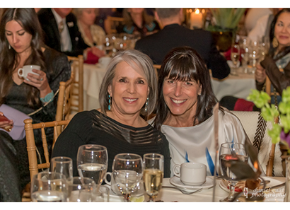 Michelle Lujan Grisham, Jenny Kimball Sitting At A Table With Wine Glasses